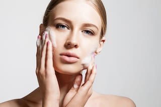 Woman clears a face with skin foam Woman clears a face with skin foam